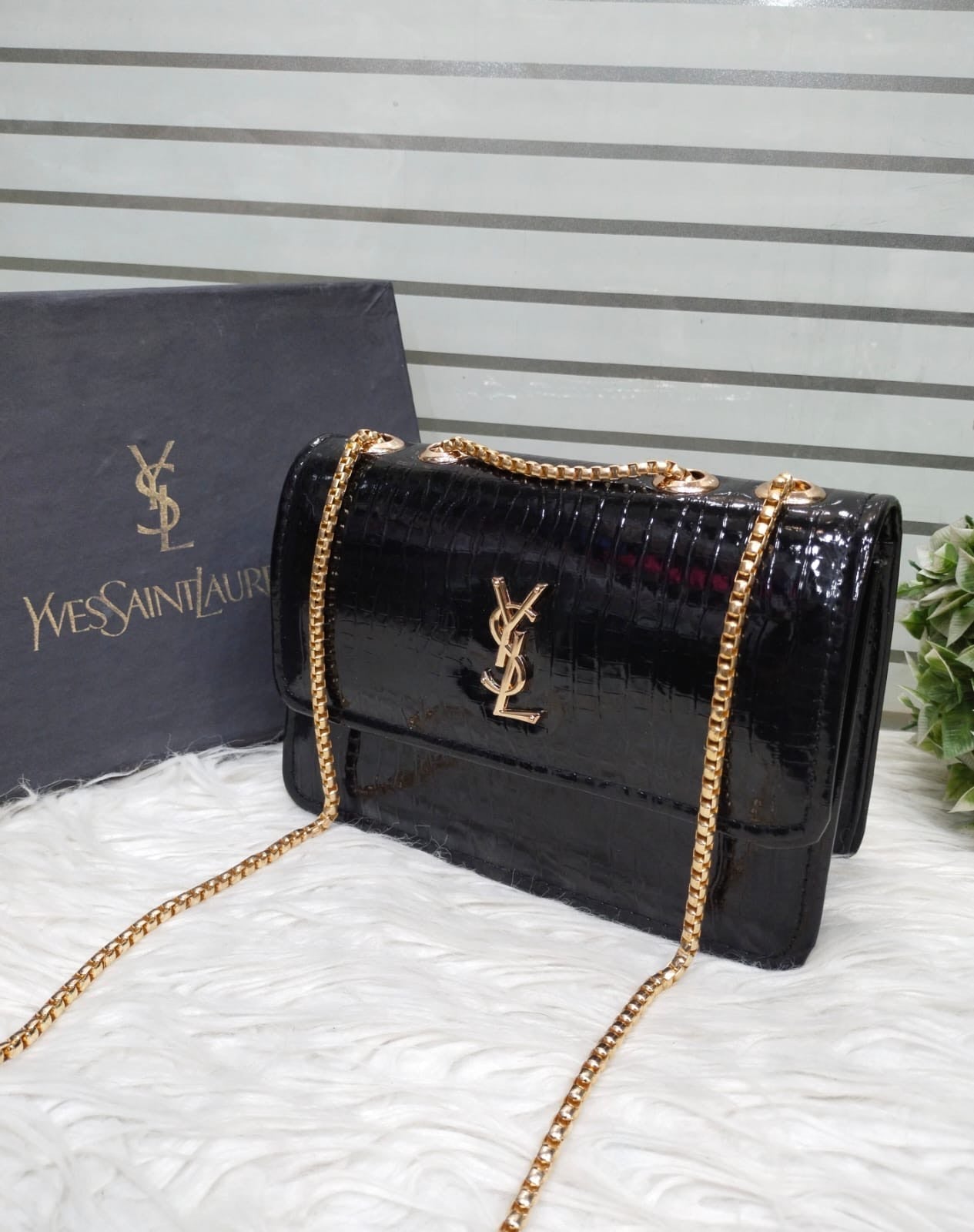 black, crocodile-embossed leather crossbody bag featuring the iconic YSL (Yves Saint Laurent) logo in gold-tone hardware.
