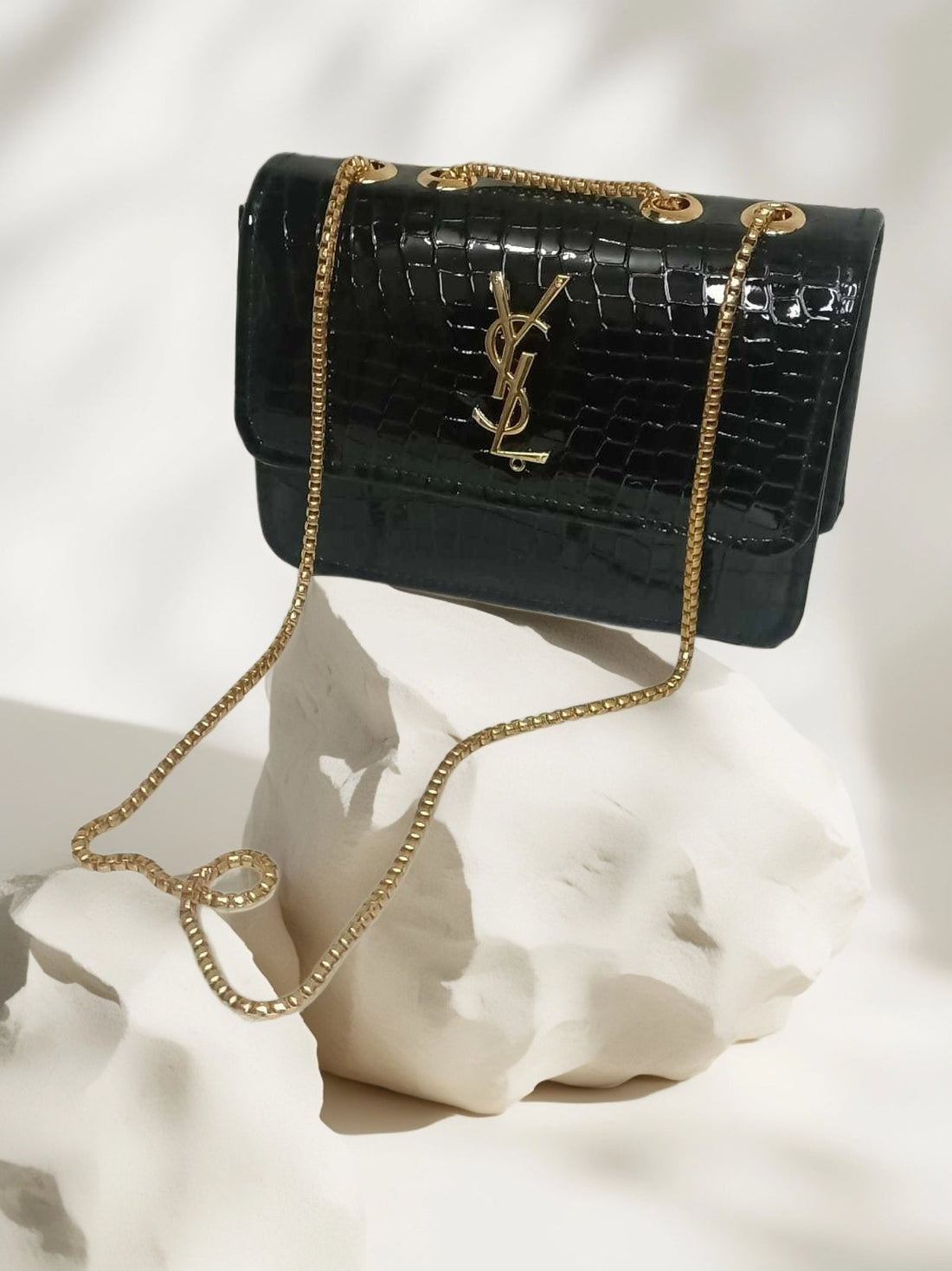 black, crocodile-embossed leather crossbody bag featuring the iconic YSL (Yves Saint Laurent) logo in gold-tone hardware.